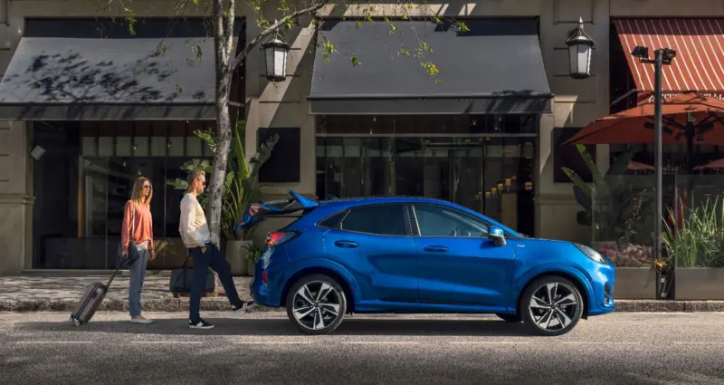 2019 Ford Puma ST-Line-oldalról, két utazó csomaggal érkező személlyel.
