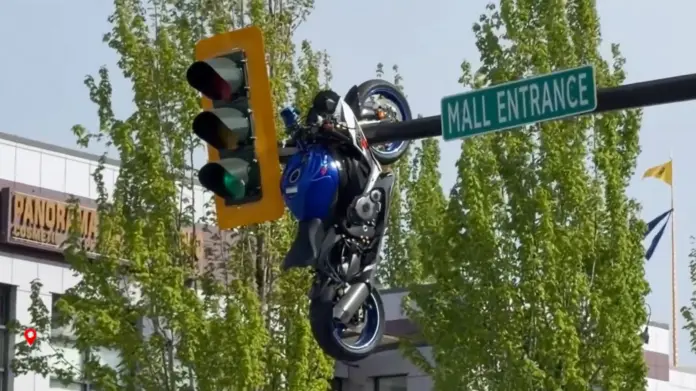 Motorkerékpár lóg a villanyoszlopról